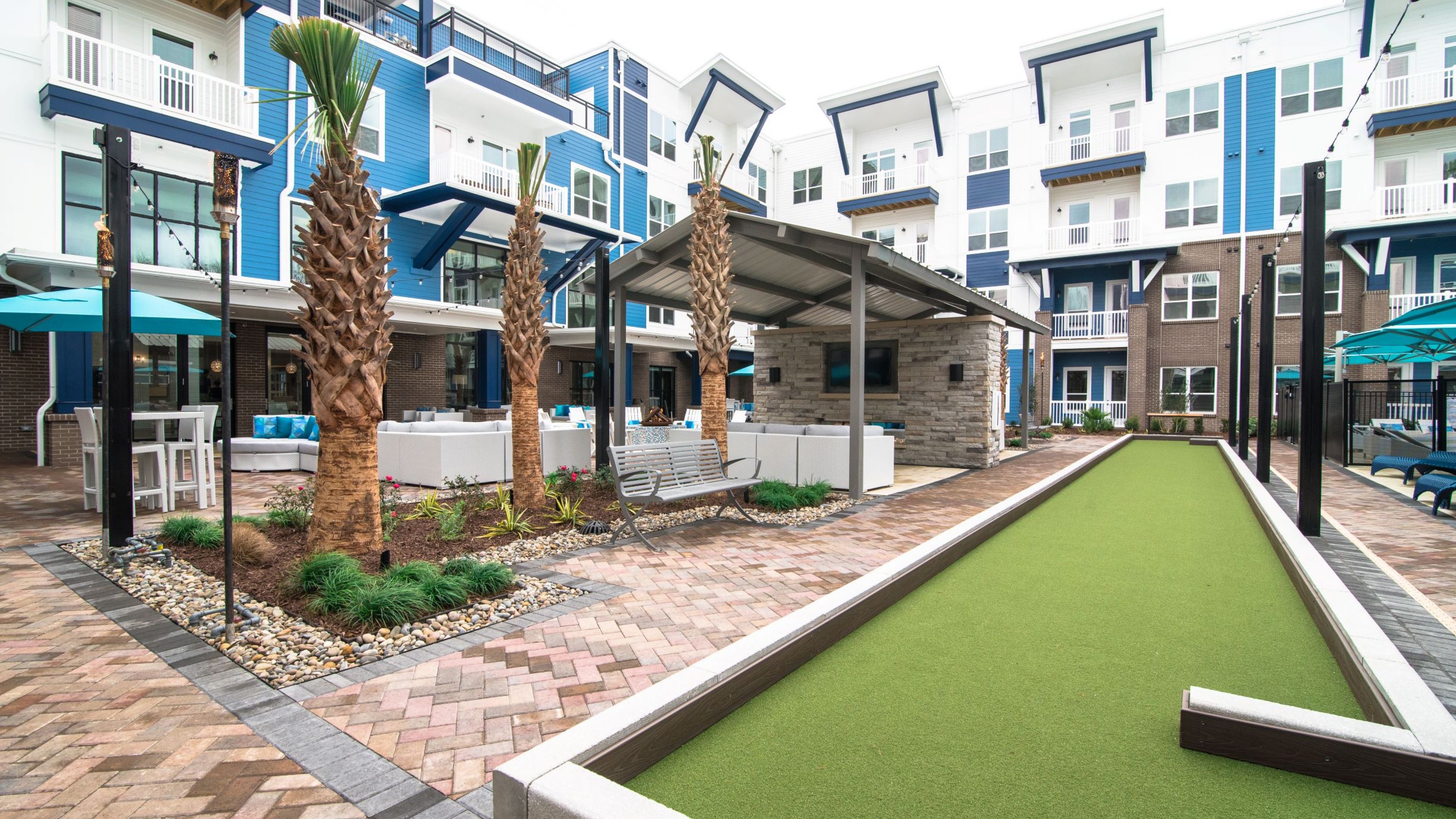 Hawthorne at Indy West beautiful outdoor courtyard with an outdoor lounge area, bocce ball court and lawn, and cabanas