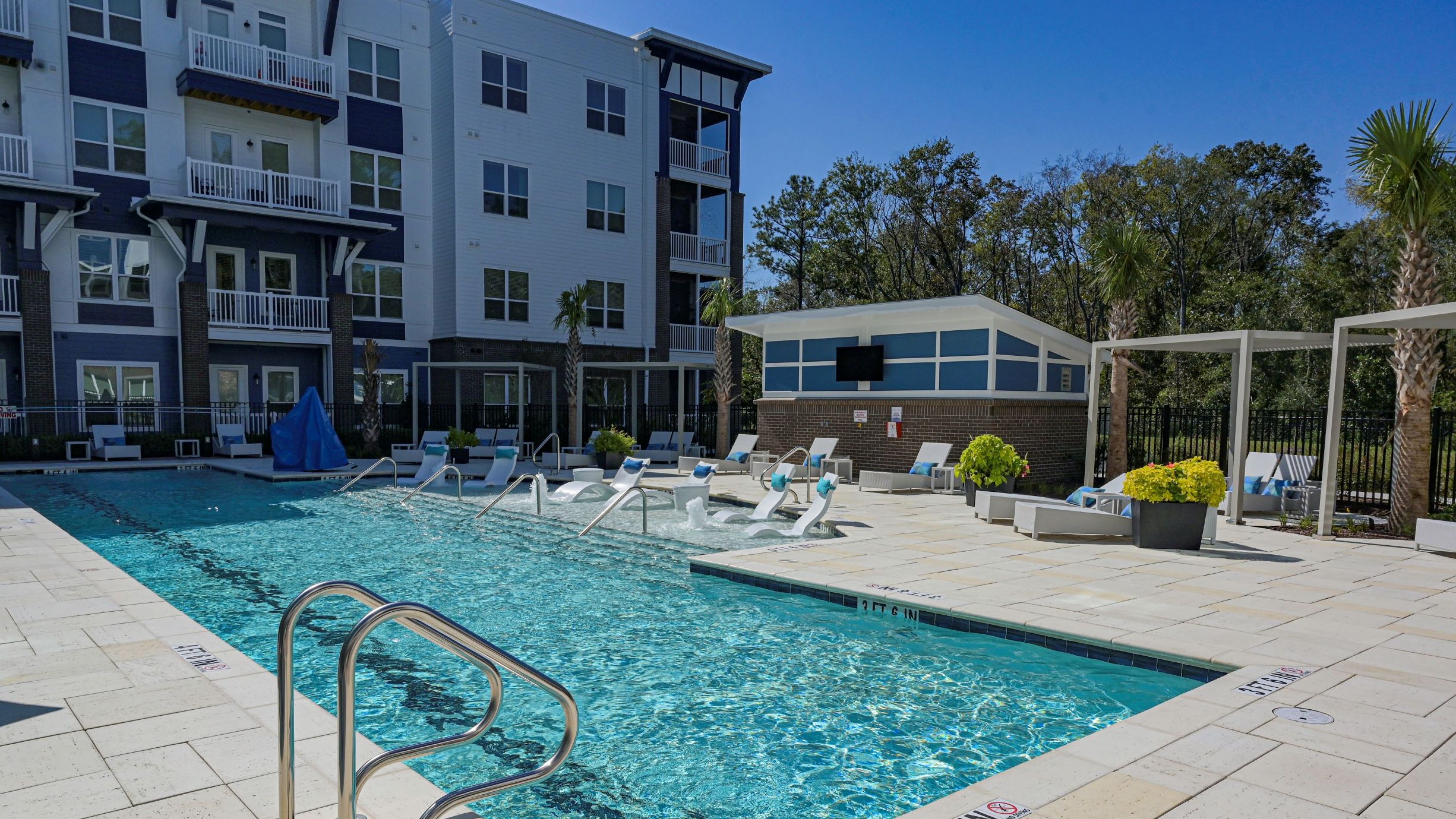Hawthorne at Indy West luxury outdoor pool with surrounding lounge seating in front of apartments building